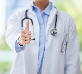 Image showing Thumbs up, doctor and hand of woman or medical worker on a blurred background. Healthcare expert finger, like or approval hands, okay or success, welcome or motivation, yes signal and thank you sign