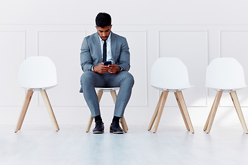 Image showing Human resources, recruitment and man on chair with phone in empty corporate office waiting room. Professional company interview for candidate and rejection in the job career hiring process.
