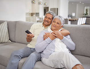 Image showing Movie streaming, living room and senior couple at home with quality time together on a sofa. Elderly people smile and hug on a house lounge couch watching tv with a relax, peace and love mindset