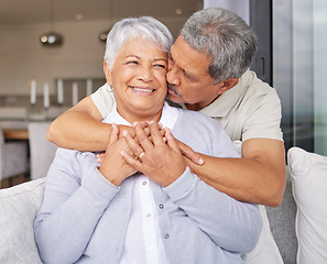 Image showing Happy senior couple kiss on sofa and smile for love, happiness and trust in family home or house living room. Elderly Mexico man and woman or people in retirement hug, kissing and romance on couch