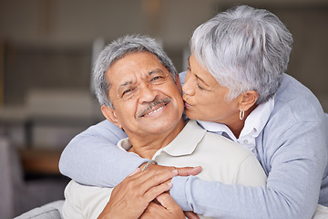 Image showing Happy Mexico senior couple kiss on living room sofa for love, care and trust in romantic relationship at house or home. Elderly people or retirement man and woman smile, hug and kissing face cheek