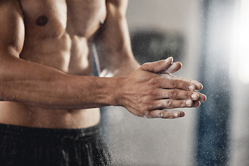 Image showing Man with sports chalk powder on his hands in the gym during a fitness training or workout. Closeup of a muscular guy with active, healthy and wellness lifestyle preparing for boxing or weightlifting