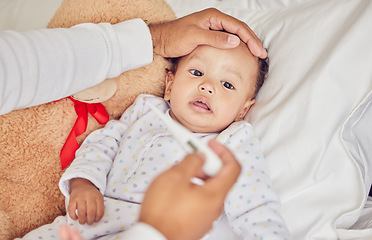 Image showing Baby, sick with covid and fever with a thermometer from a parent of an unwell kid in bed of the bedroom of their home. Hand, forehead and healthcare with a child feeling unwell and resting in a house