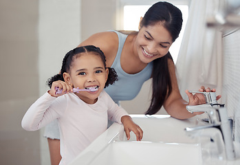 Image showing Brushing teeth, girl or mother teaching learning child personal hygiene, dental care or healthcare in house or family home bathroom. Happy smile woman, parent and kid in wellness with sink toothbrush