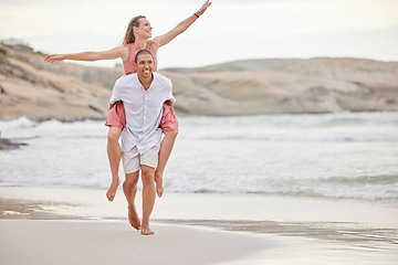 Image showing Beach, love and summer couple walking on sand together for relaxing date with piggy back. Young, happy and playful people in romantic interracial relationship enjoy ocean vacation break.