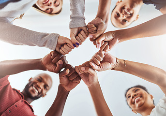 Image showing Teamwork, unity and hands or fist for support, trust and community below blue sky. Diversity group men and women friends standing together for teamwork, collaboration and help during team building