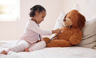 Image showing Girl, teddy bear and stethoscope in hospital game in medical, healthcare and wellness bedroom. Happy smile, curious orphan child or fun patient in medicine play activity in pediatric community center