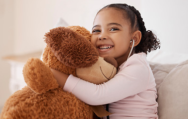 Image showing Children, teddy bear and girl with a child hugging her stuffed animal with a smile in her house. Kids, happy and safe with an adorable or cute female kid holding a fluffy toy while sitting on a bed