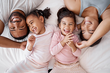 Image showing Happy family, love and morning tickling with parents and children lying and playing in bedroom for fun together at home from above. Laughing and man and woman spending time with playful kids to bond