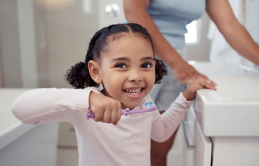 Image showing Children, toothbrush and toothpaste with a girl brushing teeth in the bathroom at home for dental hygiene or care. Healthcare, teeth and mouth with a cute female child practicing good oral habits