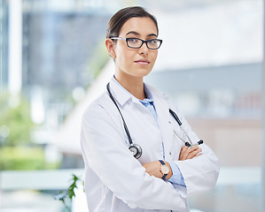 Image showing Portrait of a doctor with arms crossed in her consultation office with glasses and a stethoscope. Woman healthcare professional standing in a room in a medicare hospital, clinic or surgery center.