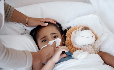 Image showing Sick child, concerned mother and covid symptoms while in bed for health problem or fever while wiping nose with tissue. Woman caring for sad girl with virus, cold or flu in bedroom at home