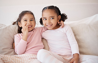 Image showing Family, children and bonding by sisters on a sofa, laugh and relax while sharing a secret in a living room. Happy, play and cheerful girls enjoying a fun morning together, looking sweet and cute