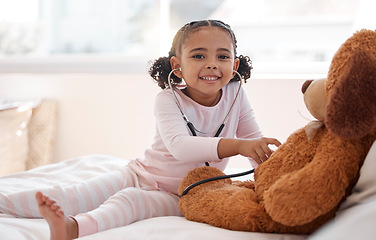 Image showing Children, stethoscope and teddy bear with a girl playing doctor in her bedroom at home with a stuffed animal. Imagination, healthcare and medicine with a cute female child being a pretend nurse
