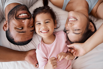 Image showing Family, children and love with a girl and parents lying on the bed in a bedroom of their home together from above. Kids, happy and diversity with a mother, father and daughter bonding in their house