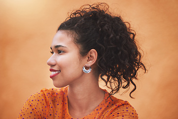 Image showing Face, beauty and hair with a woman in studio against an orange background while posing with a smile from the side. Fashion, happy and idea with a young female standing on a bright color wall indoor