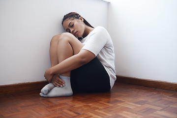 Image showing Depression, anxiety and lonely woman sitting in a corner suffering from mental health issues or problems. Black female in stress, depressed or abuse alone on a wooden floor in apartment, home or room