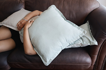 Image showing Tired, depressed girl sleeping under pillow on sofa in the living room. Woman hide feeling sad or anxiety and problem with depression, mental health and fatigue or fear on couch in the lounge