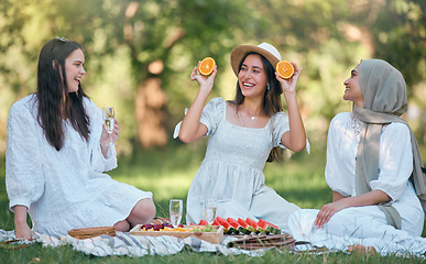 Image showing Diversity, Islamic and friends on a fruit picnic on grass in nature enjoying orange, watermelon and fun jokes. Muslim, smile and happy women laughing and smiling together at a natural park for lunch