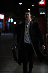 Image showing Smiling Meedle Eastern man walking down street near modern office building,