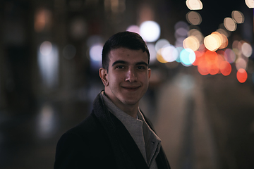 Image showing Smiling Meedle Eastern man walking down street near modern office building,