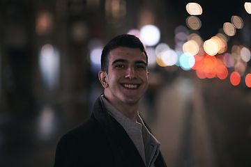 Image showing Smiling Meedle Eastern man walking down street near modern office building,