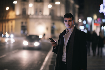 Image showing Smiling Meedle Eastern man walking down street near modern office building,