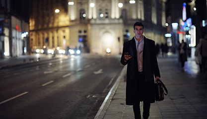 Image showing Smiling Meedle Eastern man walking down street near modern office building,