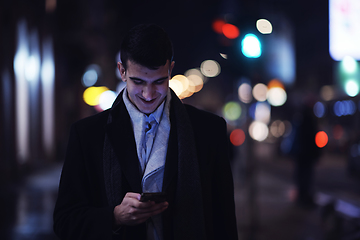 Image showing Smiling Meedle Eastern man walking down street near modern office building,