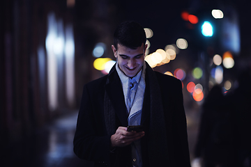 Image showing Smiling Meedle Eastern man walking down street near modern office building,