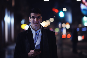 Image showing Smiling Meedle Eastern man walking down street near modern office building,