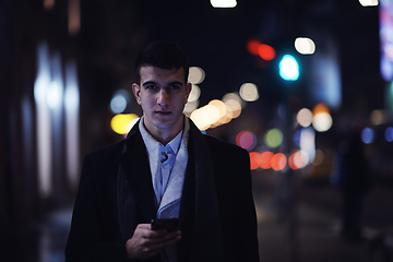 Image showing Smiling Meedle Eastern man walking down street near modern office building,