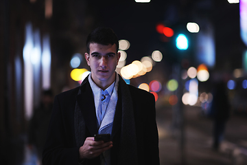 Image showing Smiling Meedle Eastern man walking down street near modern office building,