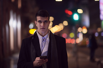 Image showing Smiling Meedle Eastern man walking down street near modern office building,