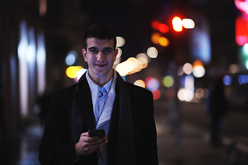 Image showing Smiling Meedle Eastern man walking down street near modern office building,