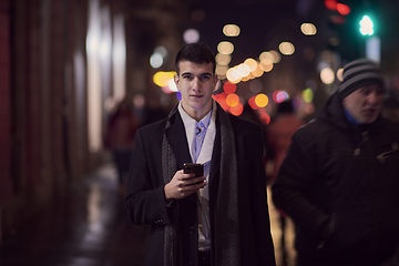 Image showing Smiling Meedle Eastern man walking down street near modern office building,