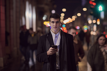 Image showing Smiling Meedle Eastern man walking down street near modern office building,