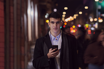 Image showing Smiling Meedle Eastern man walking down street near modern office building,