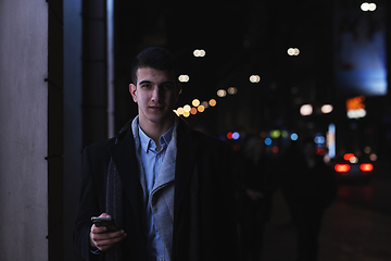 Image showing Smiling Meedle Eastern man walking down street near modern office building,