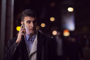 Image showing Smiling Meedle Eastern man walking down street near modern office building,