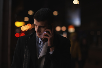 Image showing Smiling Meedle Eastern man walking down street near modern office building,