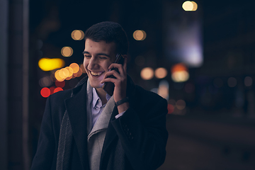 Image showing Smiling Meedle Eastern man walking down street near modern office building,