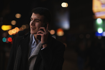 Image showing Smiling Meedle Eastern man walking down street near modern office building,