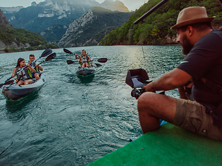 Image showing A videographer recording a group of friends kayaking together and exploring river canyons