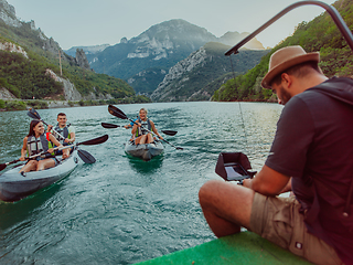 Image showing A videographer recording a group of friends kayaking together and exploring river canyons