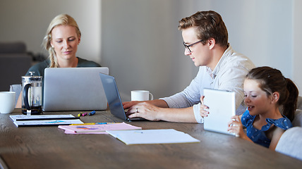 Image showing Family working on laptop with child learning on digital tablet in their home dining room table. Remote multimedia parents with finance, schedule or time management while girl kid watch cartoon online