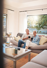 Image showing Senior couple with coffee or tea and relax on sofa in their living room happy with retirement, real estate and lifestyle. Elderly people drink on couch or in lounge together while talking of marriage