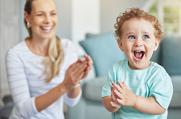 Image showing Happy, clapping hands and mother and son playing in the living room of their family home. Happiness, love and energy of parent and toddler having fun and cheering together in the lounge of a house.