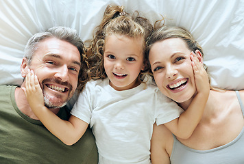 Image showing Portrait of family home, girl and parents on bed for fun morning, relax lifestyle and happiness. Above of smile mom, happy dad and playful kid child face together in bedroom for love, care and joy