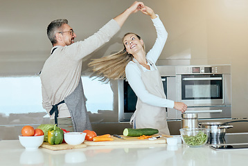 Image showing Dancing couple, cooking and love in the kitchen while preparing vegetables for a healthy, organic and vegan meal or salad. Happy man and woman with energy, joy and good health having fun at home